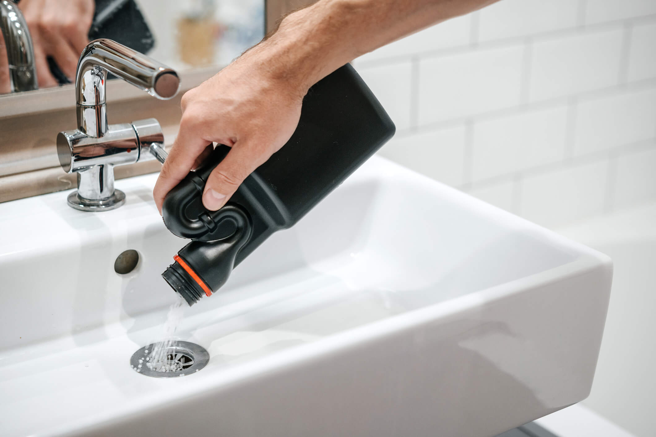 Drain cleaner being poured into a sink