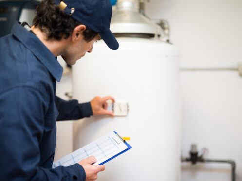 A plumber inspecting a water heater