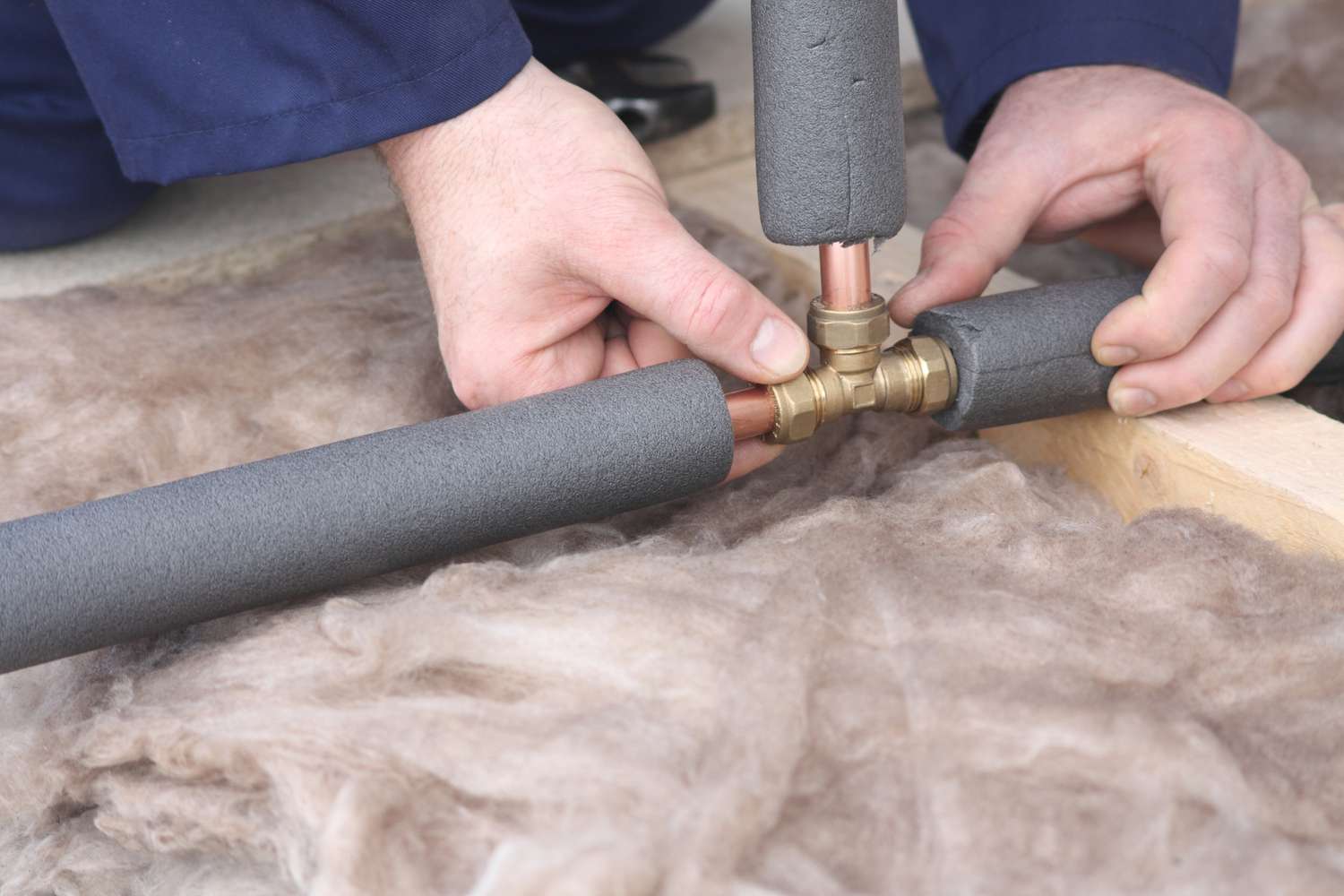 A person insulating a pipe